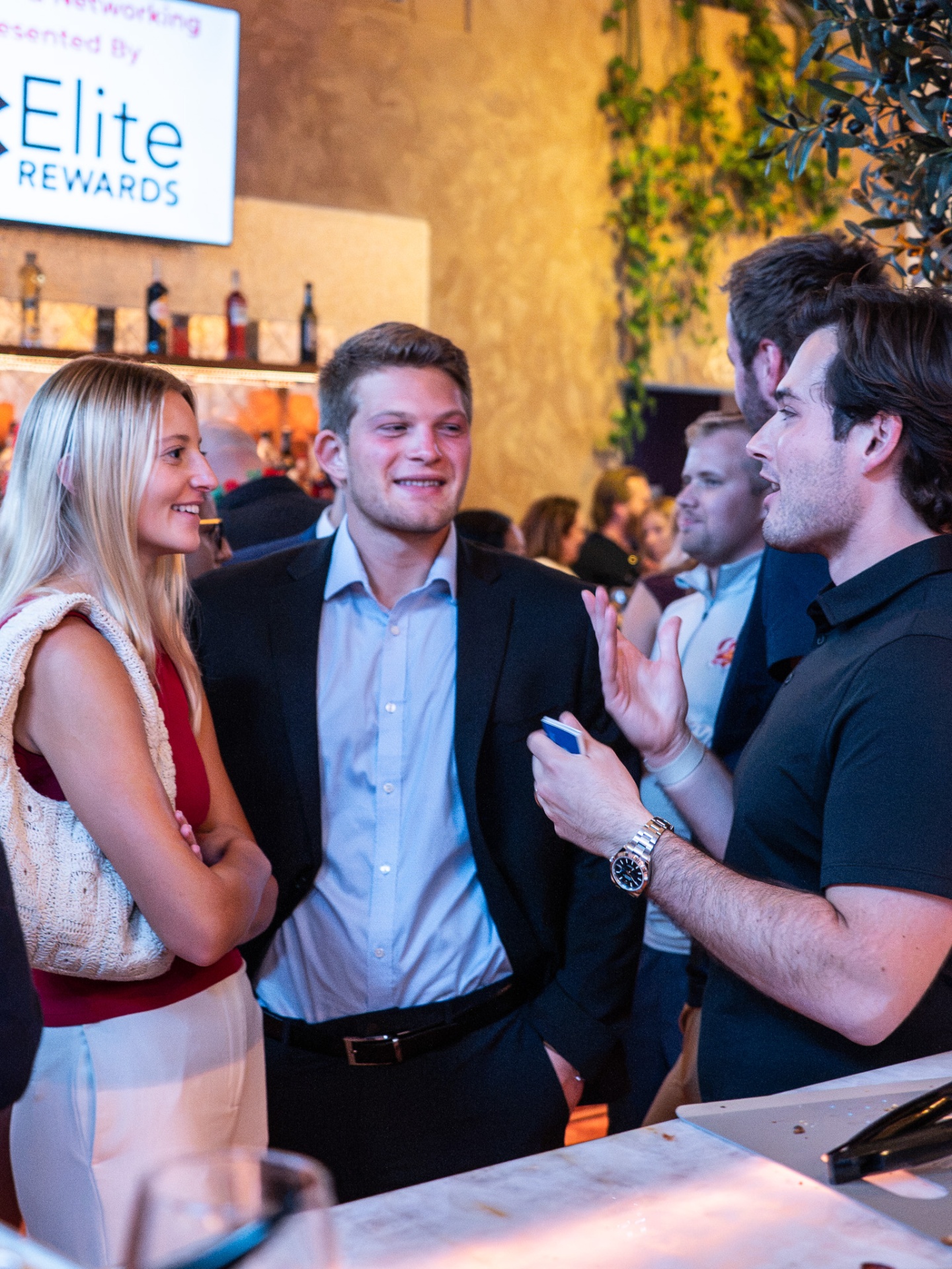 Two attendees shaking hands over pasta at a Tampa networking dinner